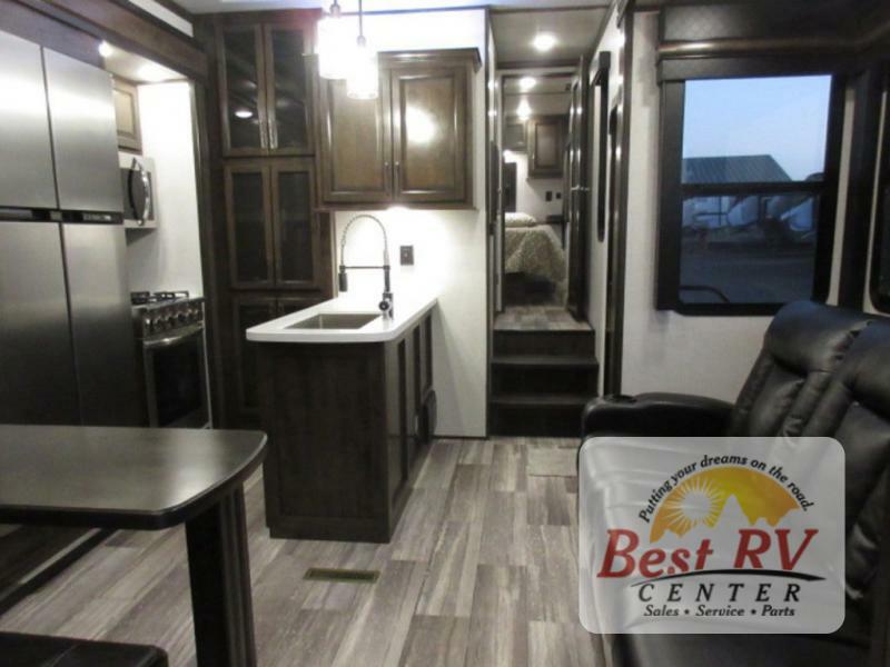 Interior view of the RV with a dinette, living space and a kitchen.