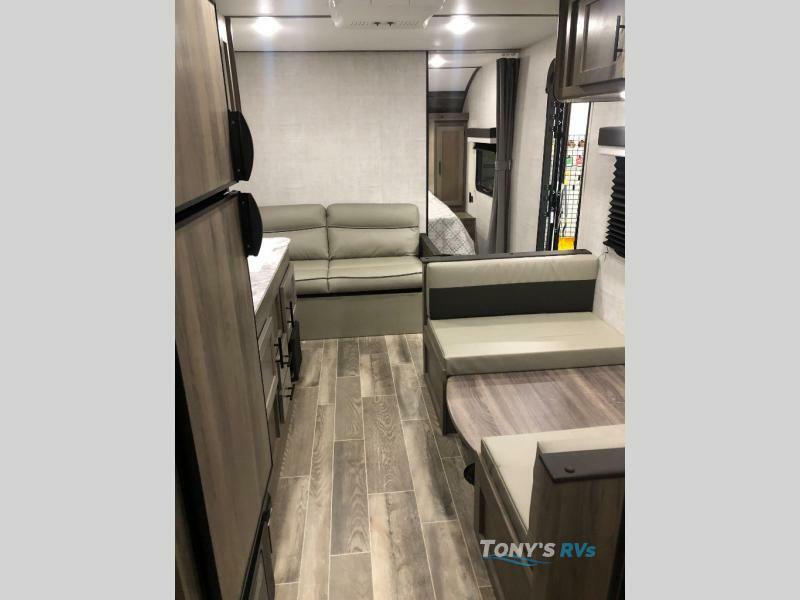 Interior view of the RV with a dinette, living space and a kitchen.