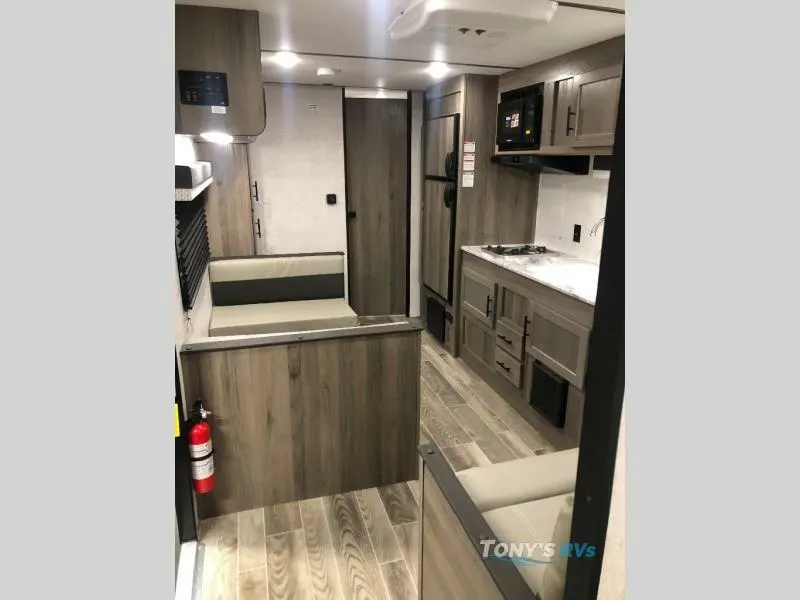 Interior view of the RV with a dinette, living space and a kitchen.