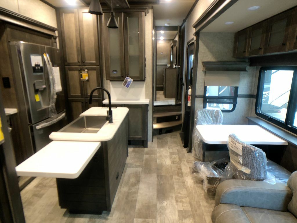 Interior view of the RV with a dinette, living space and a kitchen.