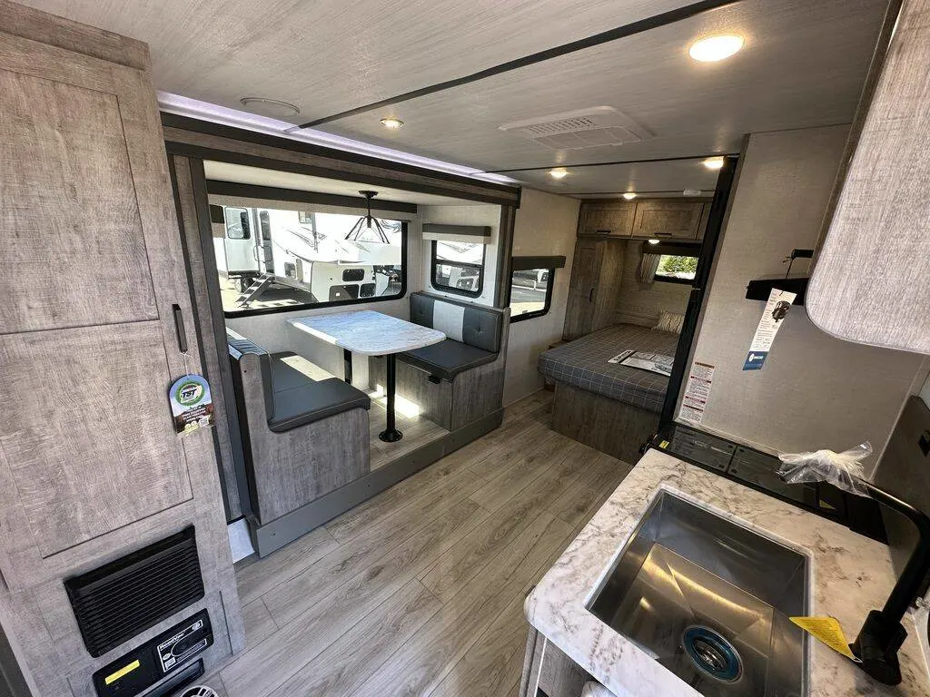 Interior view of the RV with a dinette, bedroom and a kitchen.