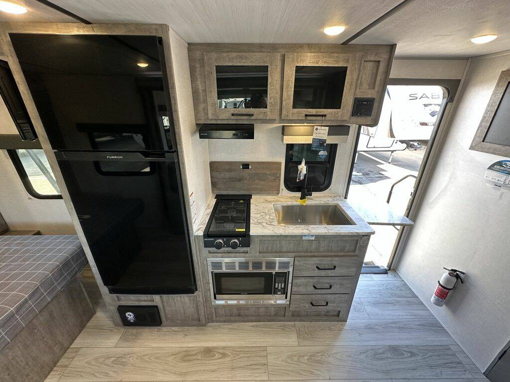 Kitchen with a gas burner, fridge, oven, sink and cabinets.