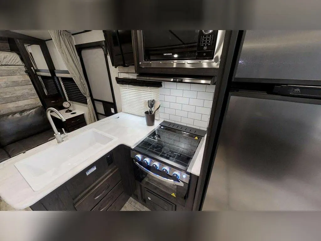 Kitchen with a gas burner, fridge, oven, sink and cabinets.