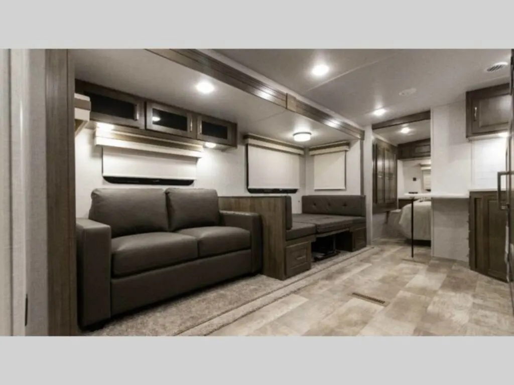 Interior view of the RV with a dinette, living space and a bedroom.