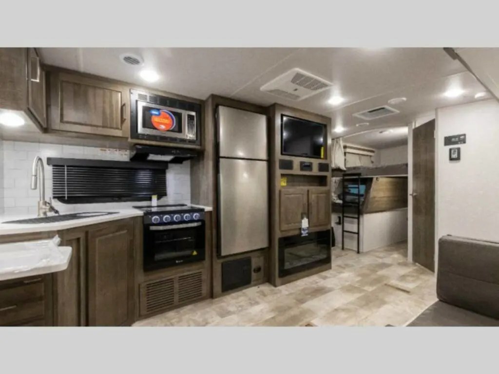 Kitchen with a gas burner, fridge, oven, sink and cabinets.