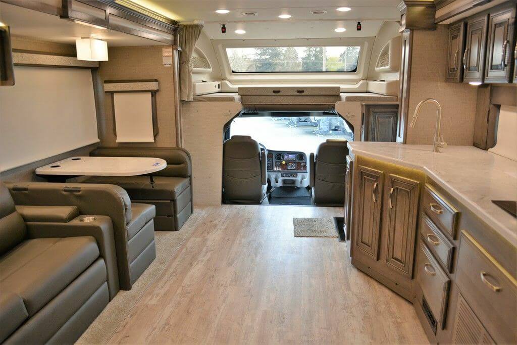 Living area with vinyl flooring and a loft bed above the cockpit.