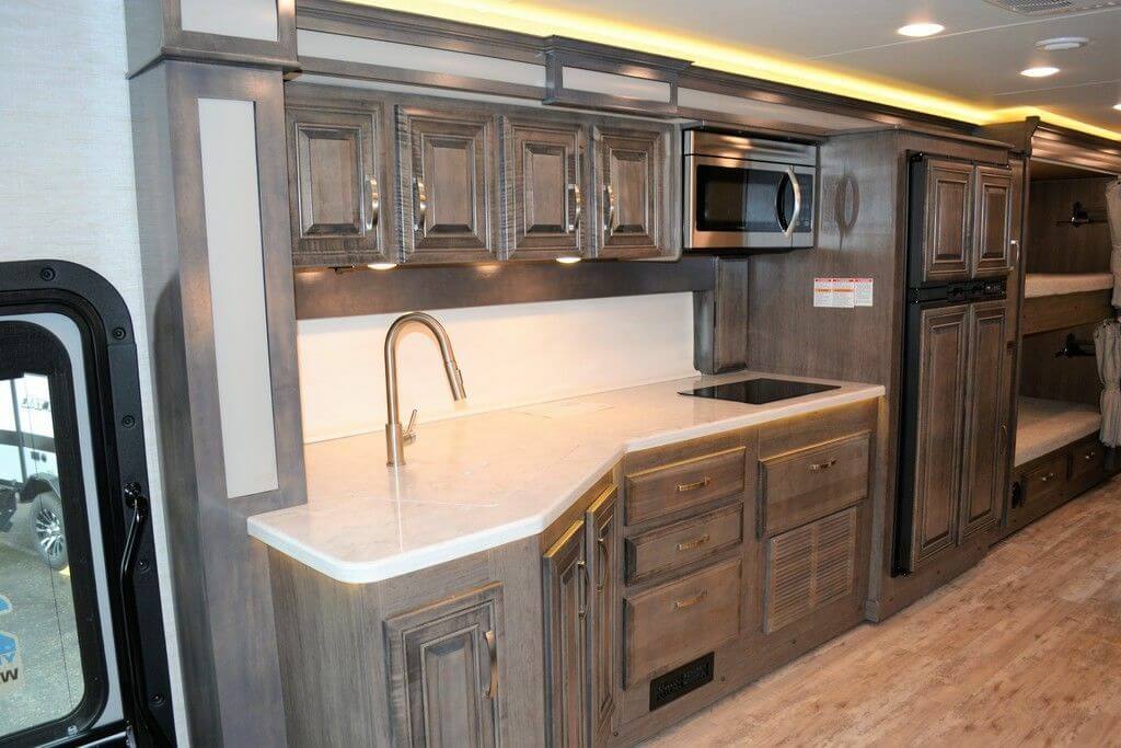 Galley with custom wood cabinets, a built-in cooktop, and a microwave.