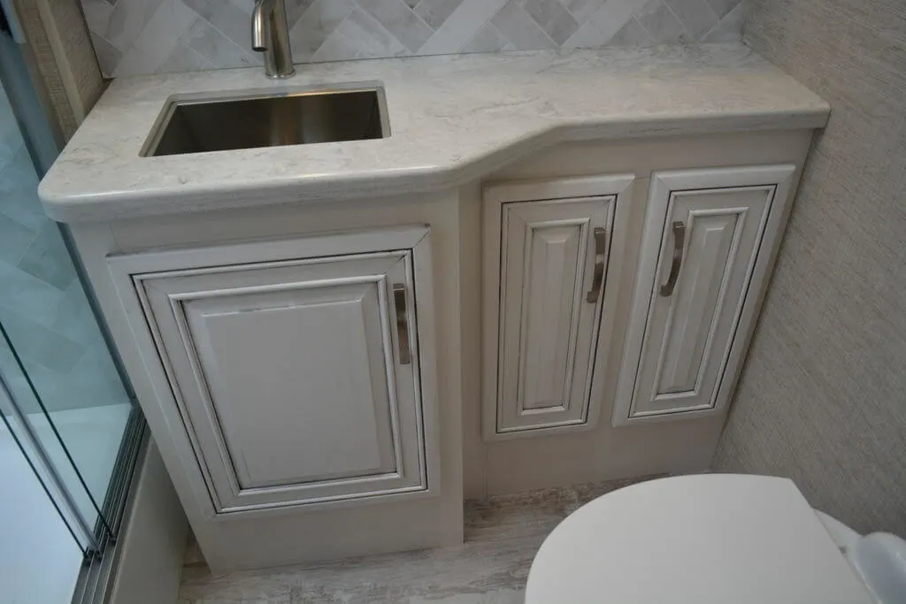 Bathroom with a sink vanity and a glass-enclosed shower.