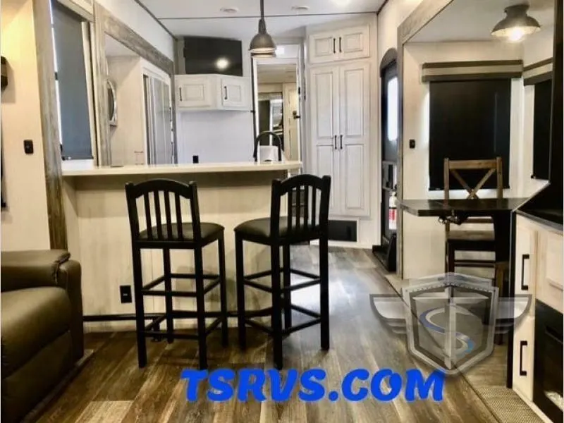 Interior view of the RV with a dinette, living space and a kitchen.