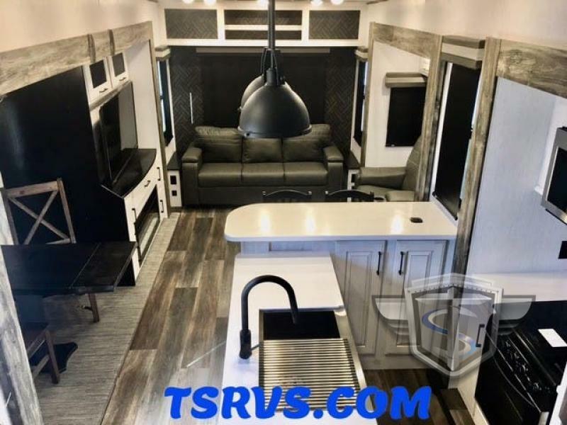 Interior view of the RV with a dinette, living space and a kitchen.