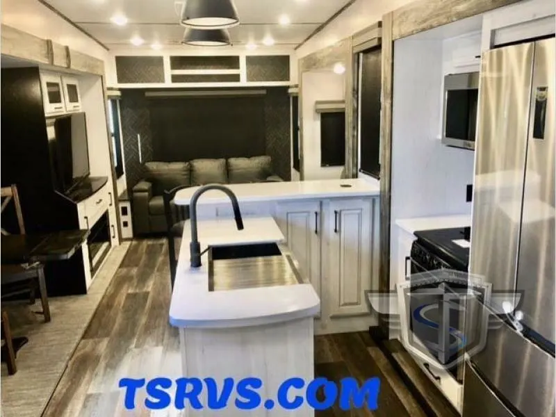 Interior view of the RV with a dinette, living space and a kitchen.