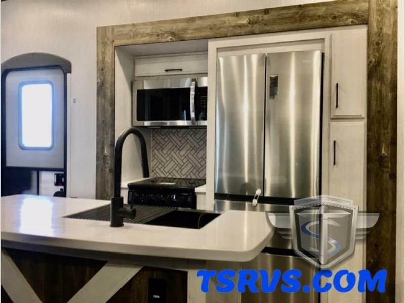 Kitchen with a gas burner, fridge, oven, sink and cabinets.