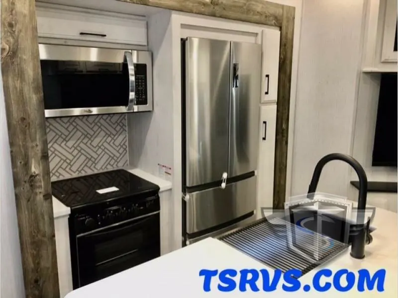 Kitchen with a gas burner, fridge, oven, sink and cabinets.