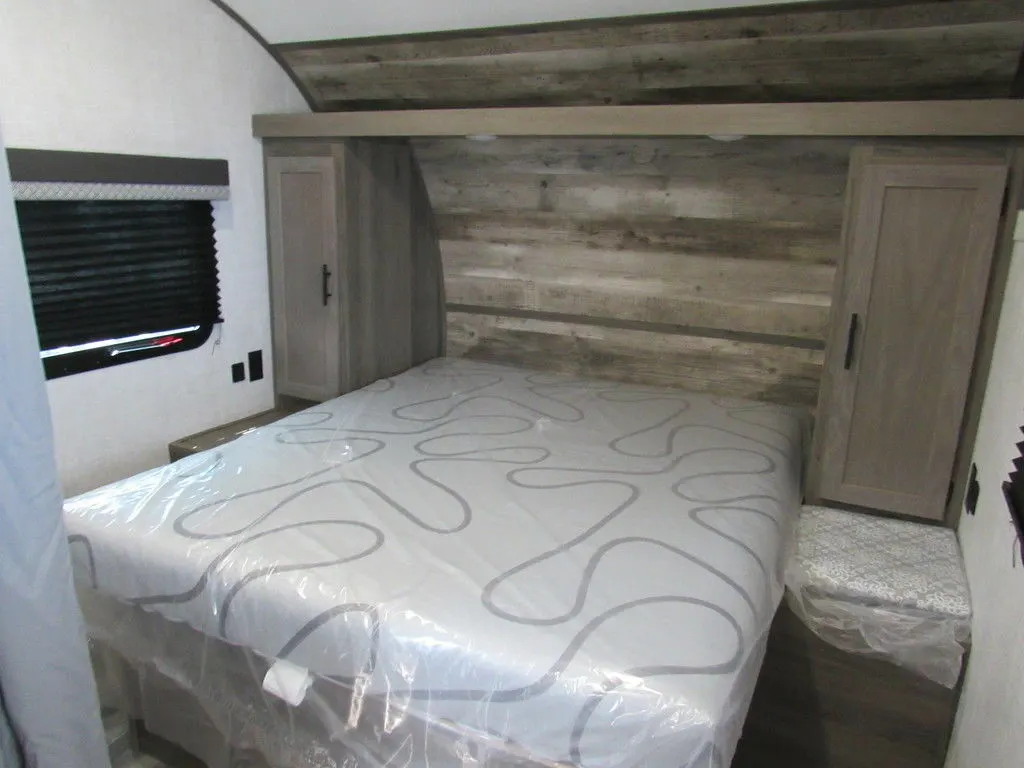 Bedroom with a queen size bed, overhead shelf and a shirt closet.