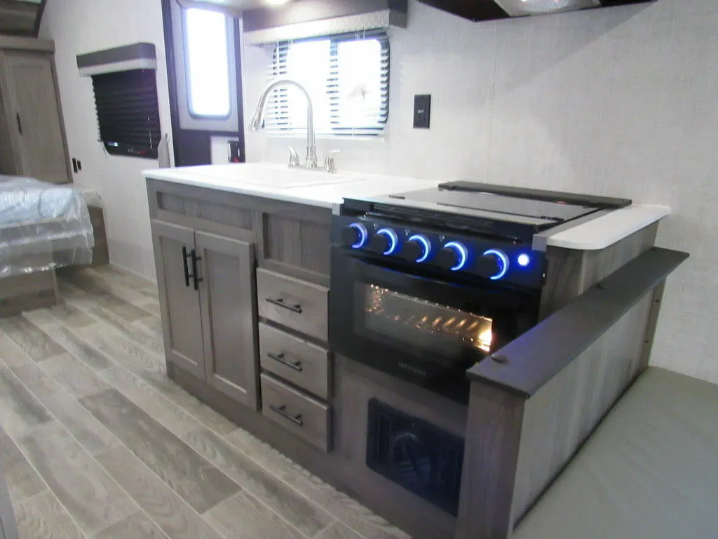 Kitchen with a gas burner, sink and cabinets.