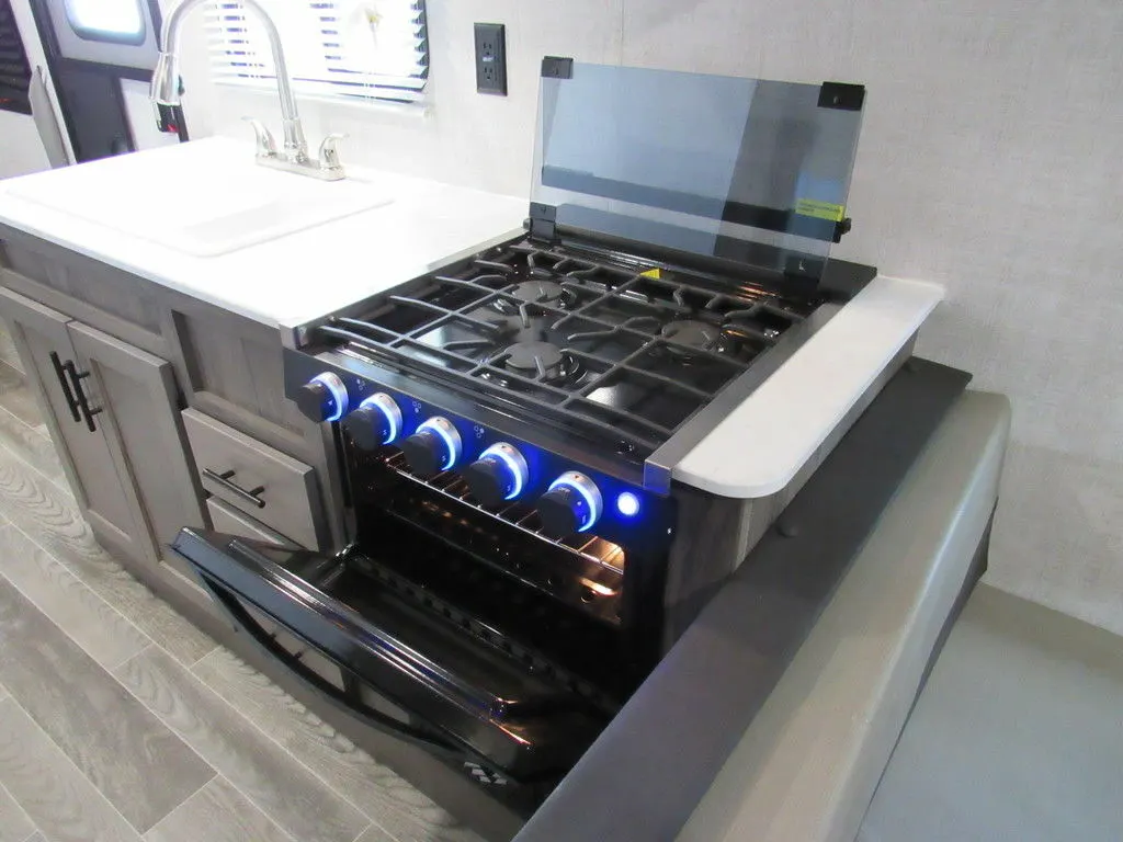 Kitchen with a gas burner, sink and cabinets.