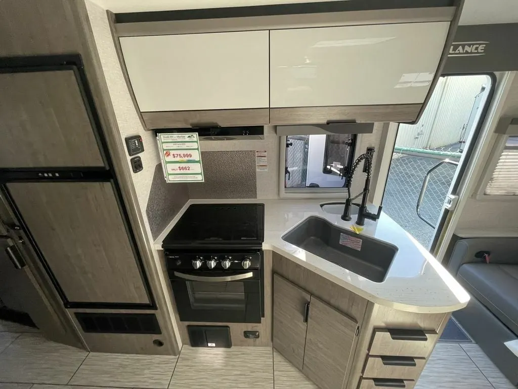 Kitchen with a gas burner, sink and cabinets.