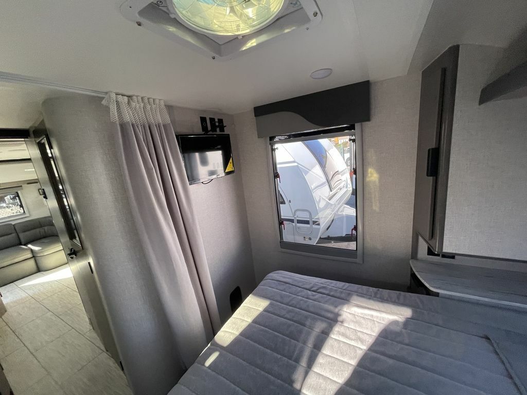 Bedroom with a queen size bed and a wall-mounted TV.