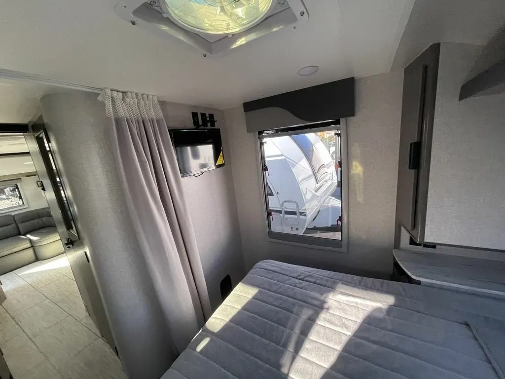 Bedroom with a queen size bed and a wall-mounted TV.