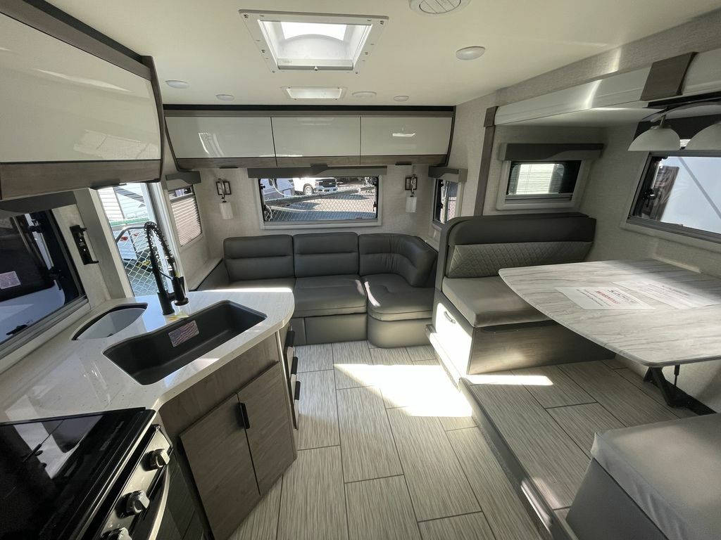 Interior view of the RV with a dinette, living space and a kitchen.