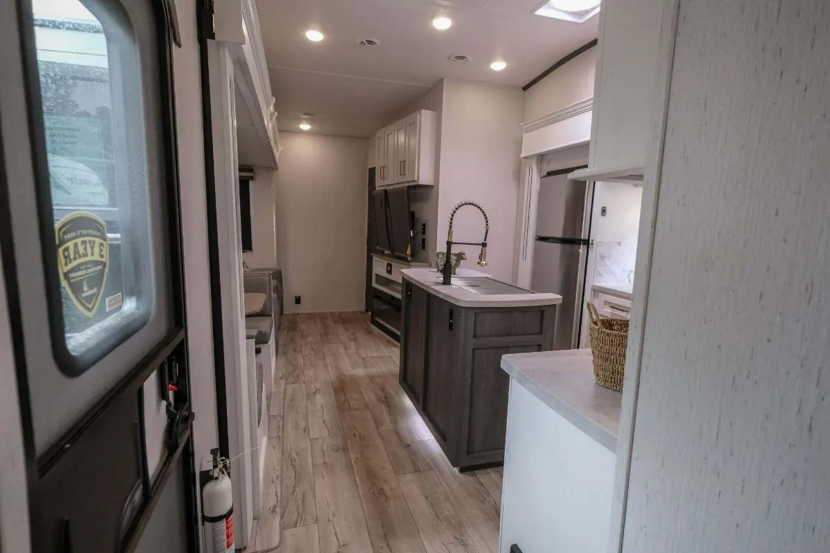 Interior view of the RV with a dinette, living space and a kitchen.