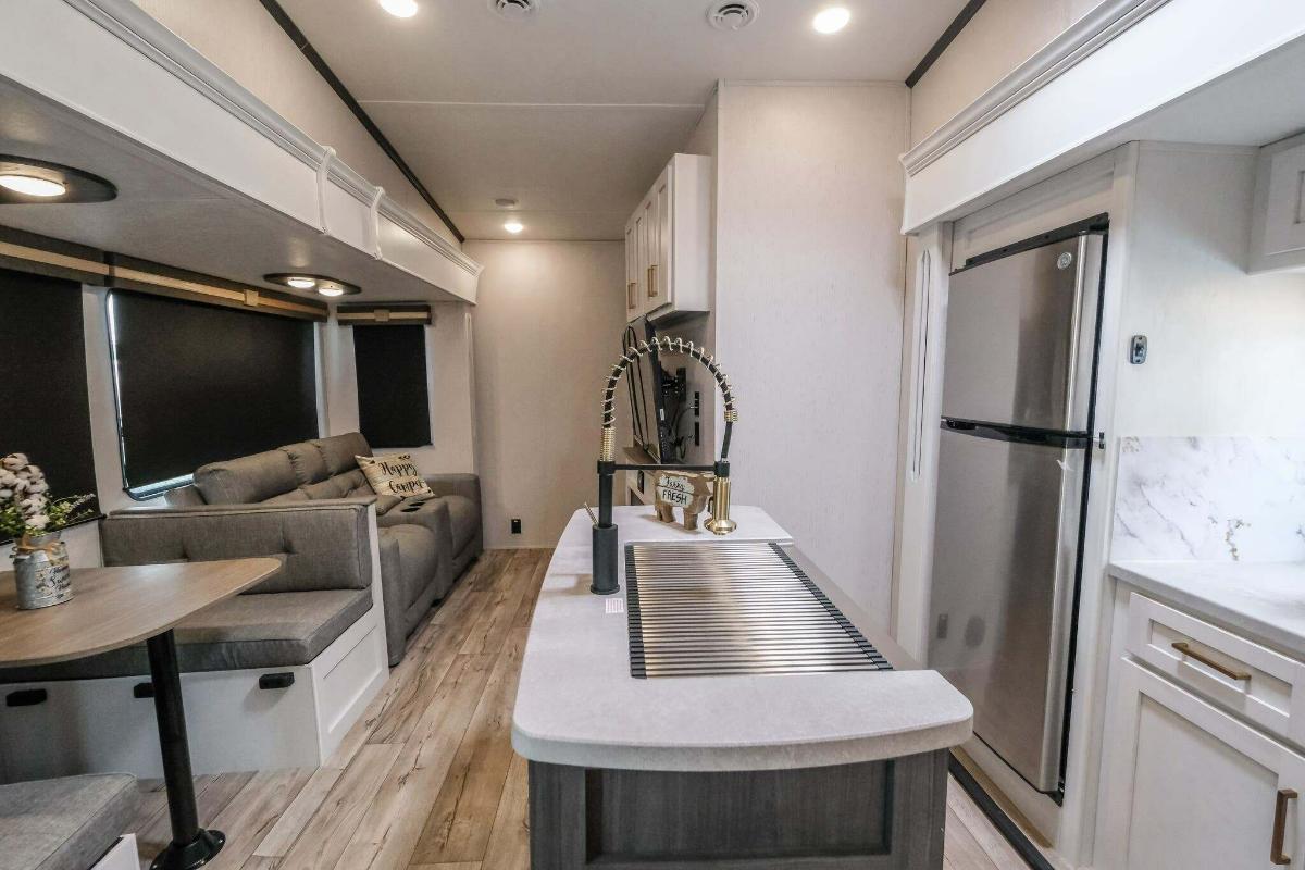 Interior view of the RV with a dinette, living space and a kitchen.