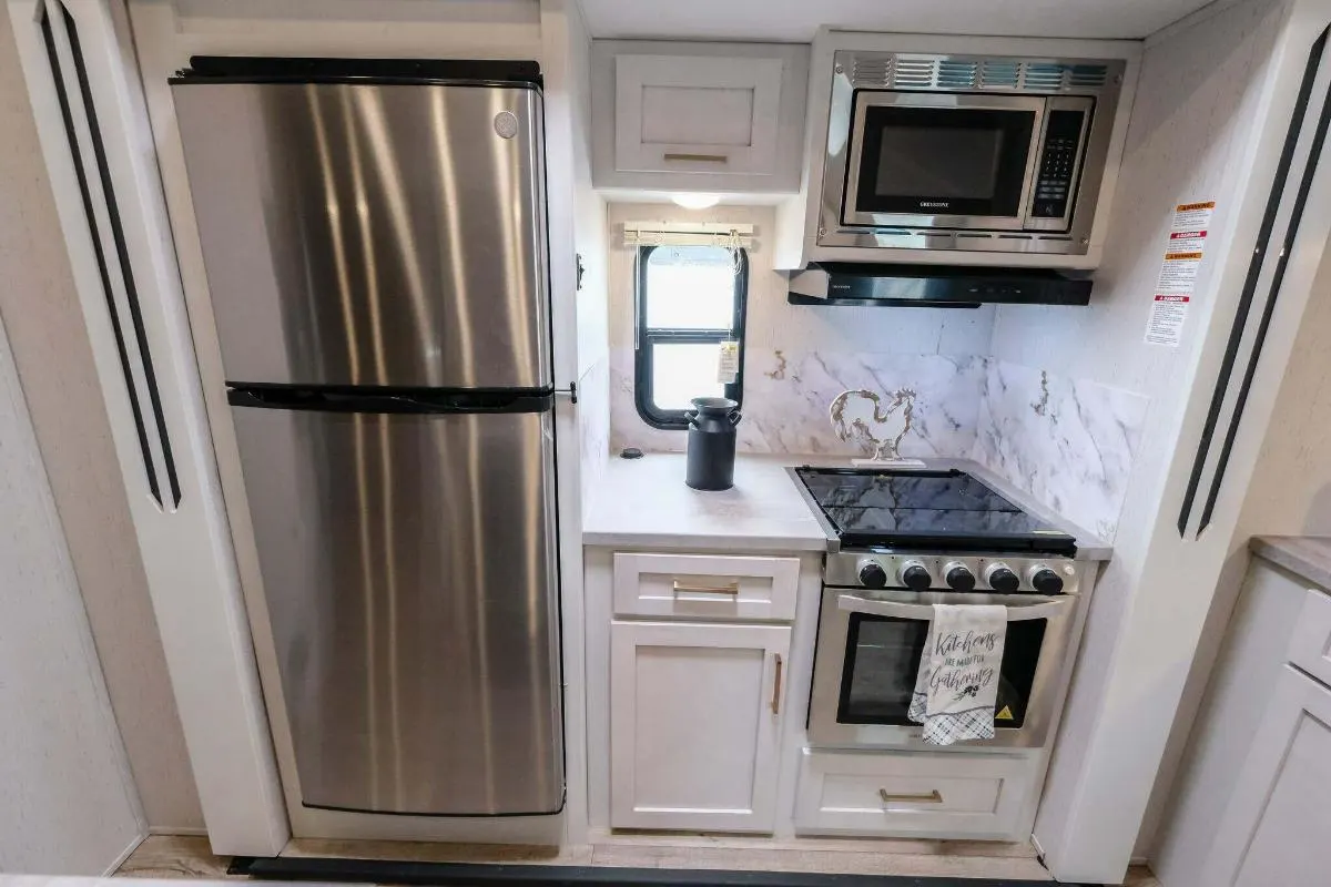 Kitchen with a gas burner, fridge, oven and cabinets.