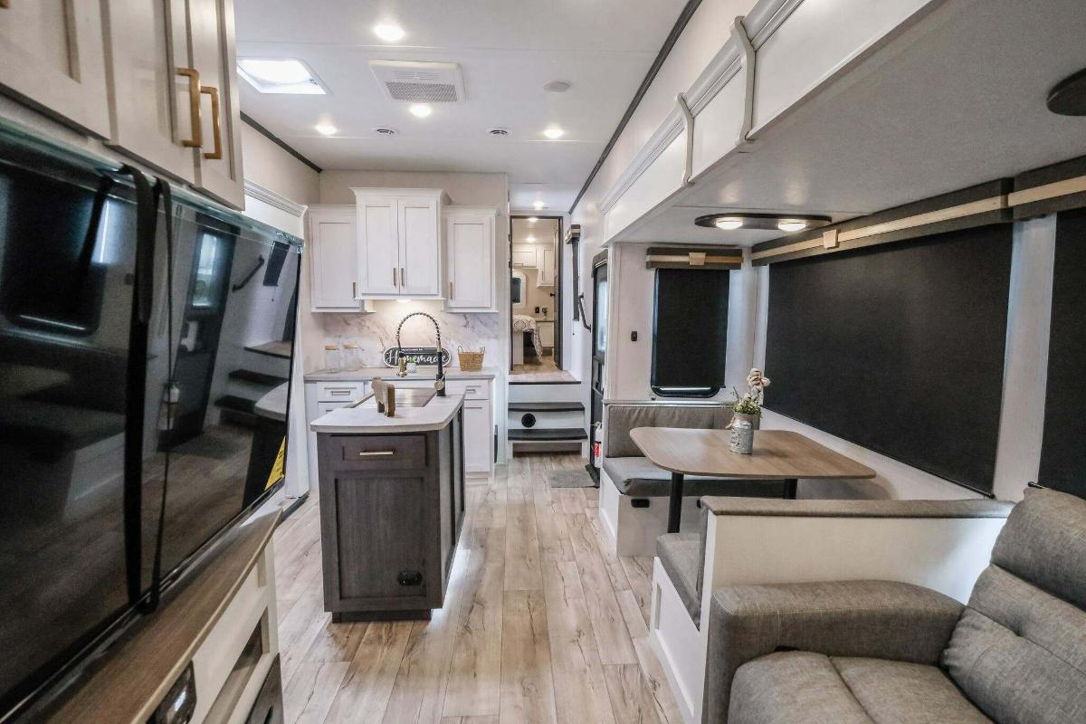 Interior view of the RV with a dinette, living space and a kitchen.