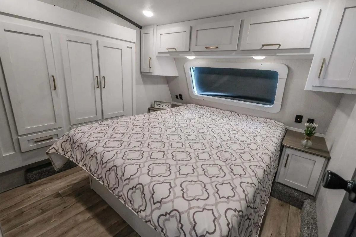 Bedroom with a queen size bed, overhead shelf and a closet.