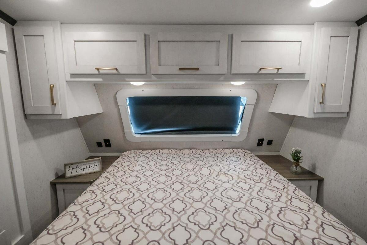 Bedroom with a queen size bed and overhead cabinets.