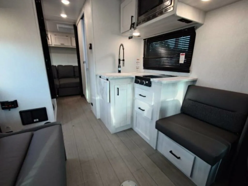 Kitchen with a gas burner, oven, sink and cabinets.