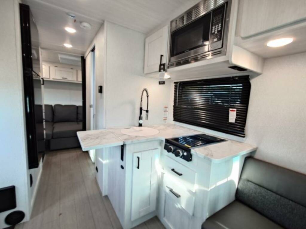 Kitchen with a gas burner, oven, sink and cabinets.