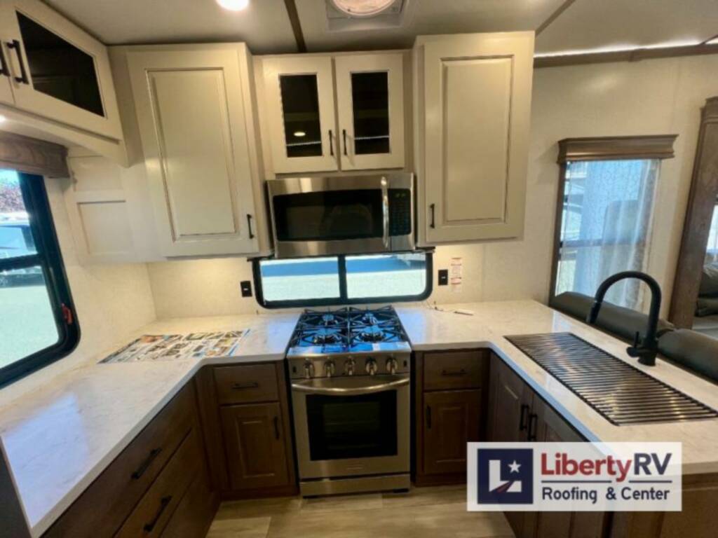 Kitchen with a gas burner, oven, sink and cabinets.