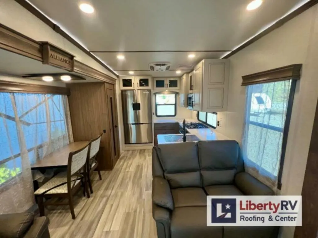 Interior view of the RV with a dinette, living area and a kitchen.