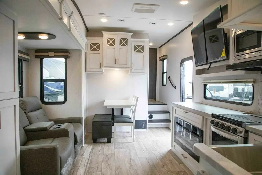 Interior view of the RV with a dinette, living space and a kitchen.