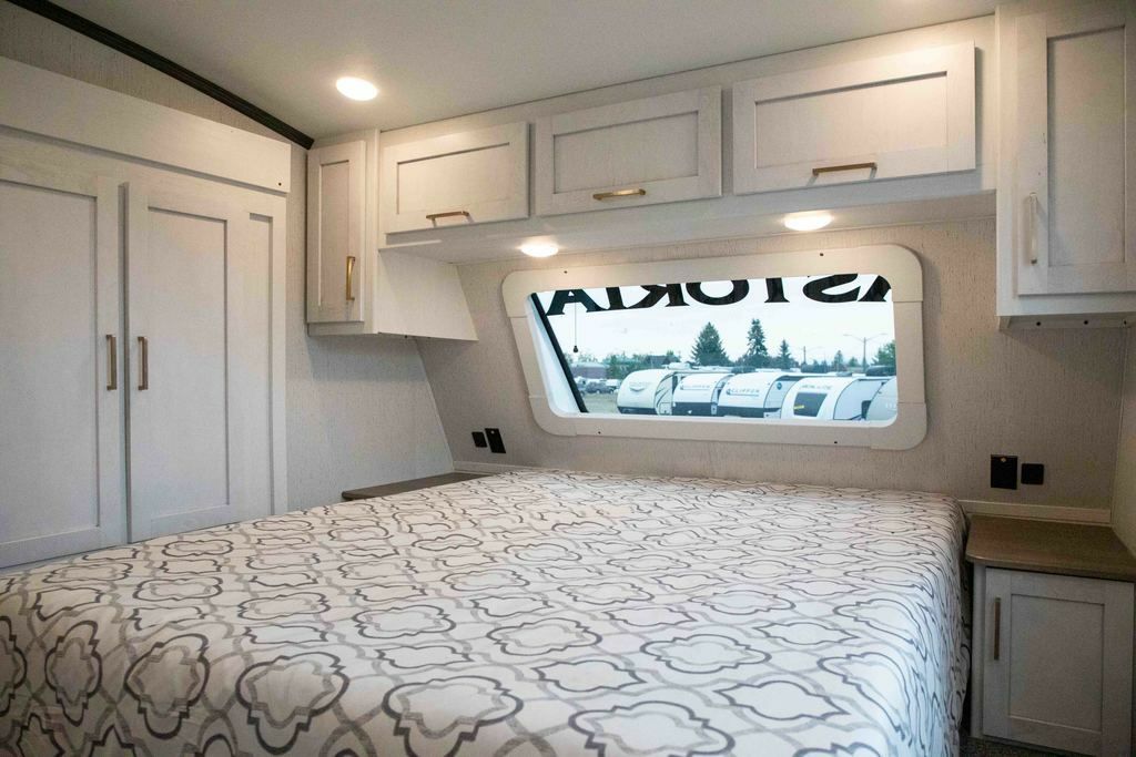 Bedroom with a queen size bed, overhead shelf and a shirt closet.