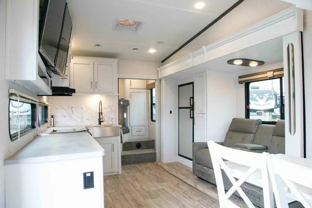 Interior view of the RV with a dinette, living space and a kitchen.