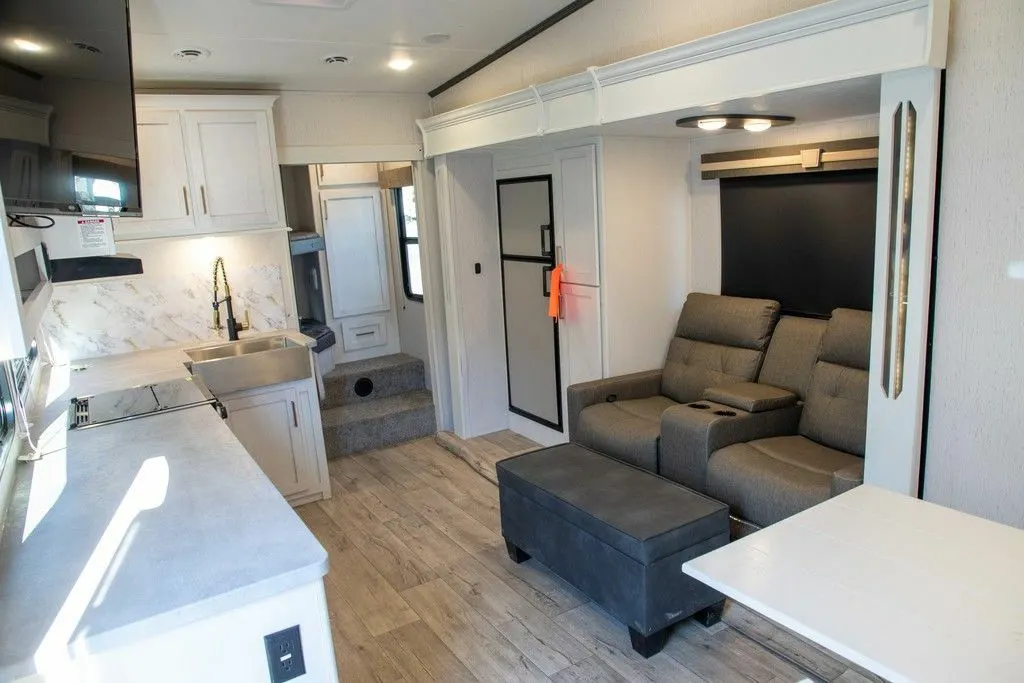 Interior view of the RV with a dinette, living space and a kitchen.