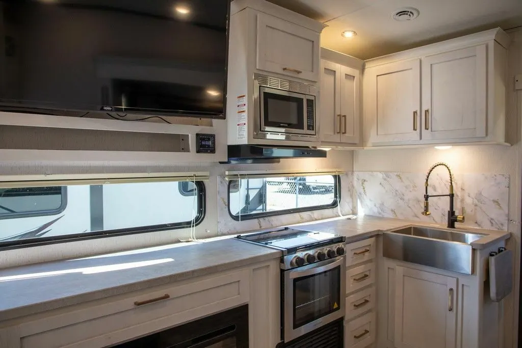 Kitchen with a gas burner, oven, sink and cabinets.