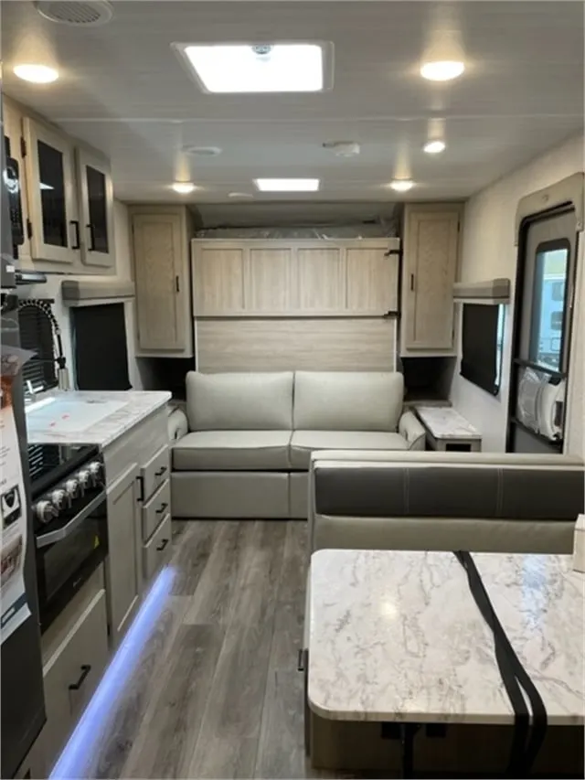 Interior view of the RV with a dinette, living space and a kitchen.