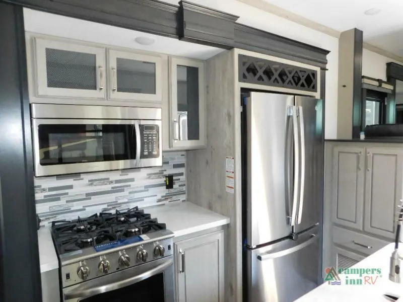 Kitchen with a gas burner, fridge, oven and cabinets.