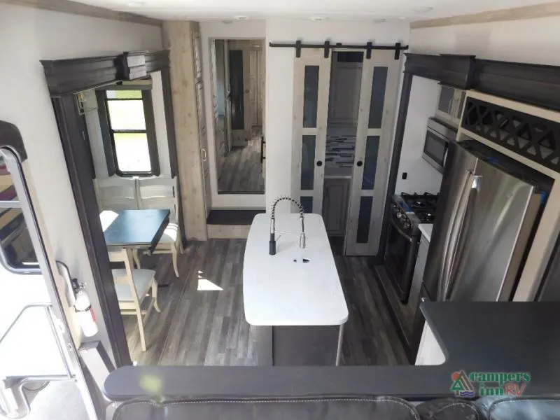 Interior view of the RV with a dinette, living space and a kitchen.