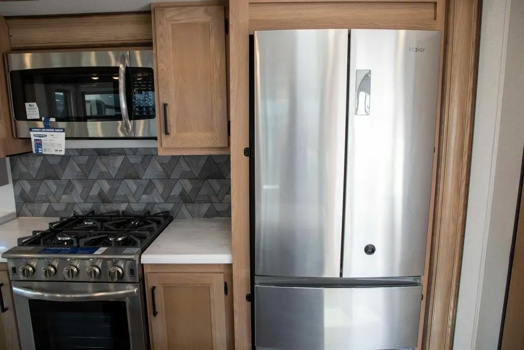 Kitchen with a gas burner, fridge, oven, and cabinets.