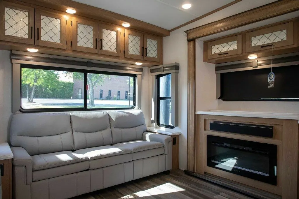 Living space with leather seats, TV and a fireplace.