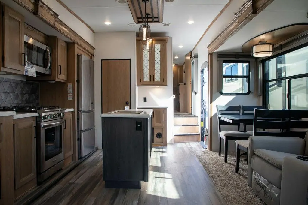 Interior view of the RV with a dinette, living space and a kitchen.