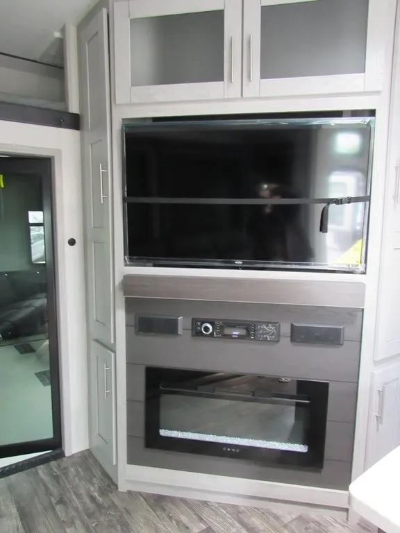 Entertainment center with a TV and a fireplace.