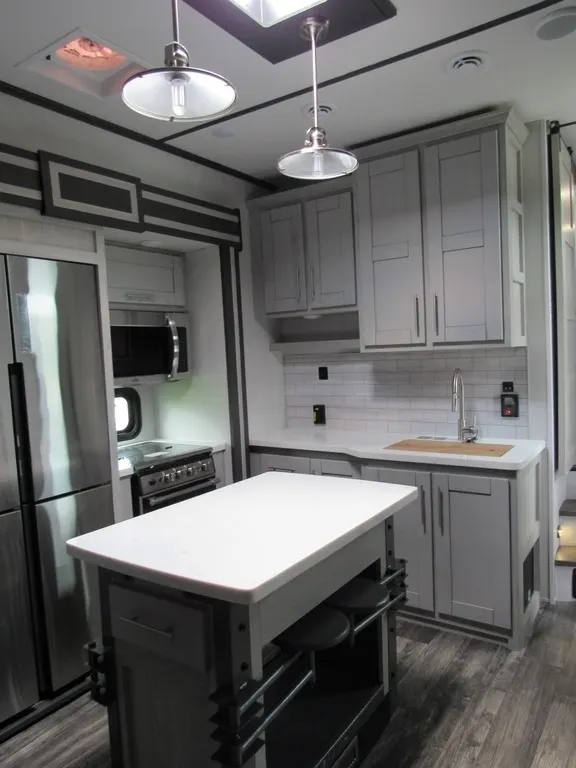 Kitchen with a gas burner, fridge, oven, sink and cabinets.