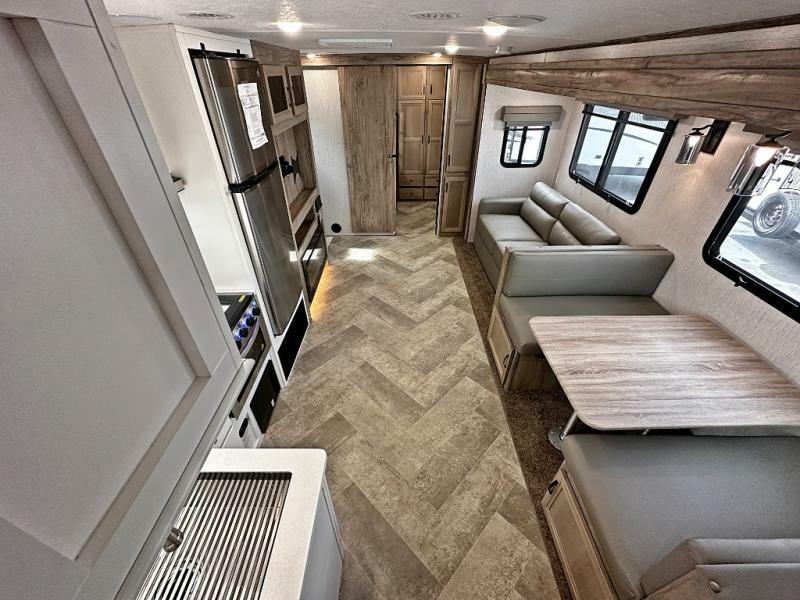 Interior view of the RV with a dinette, living space and a kitchen.