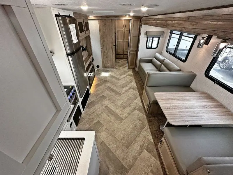 Interior view of the RV with a dinette, living space and a kitchen.