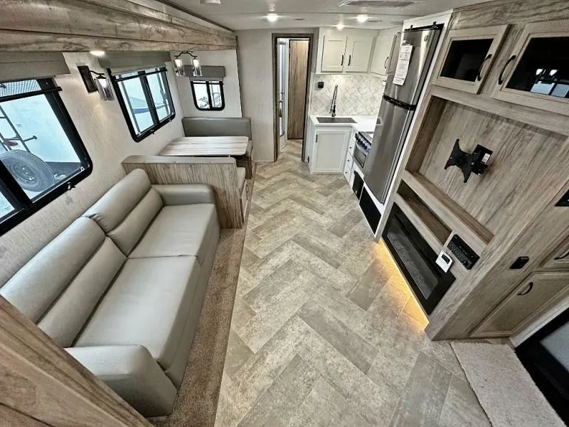 Interior view of the RV with a dinette, living space and a kitchen.